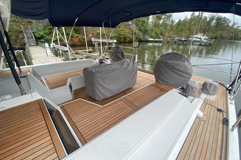 Slide: The Image of 2019 Beneteau Oceanis 51.1 yacht with covered deck, docked by a serene waterfront. - 8