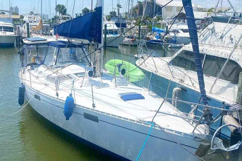 The Image of 1990 Beneteau Oceanis 390 sailboat docked in a marina, featuring blue accents. - 0