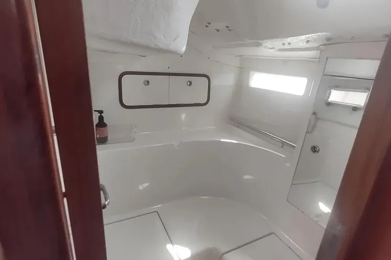 Slide: The Image of Bathroom interior of 1990 Beneteau Oceanis 390 yacht, featuring white fixtures and wooden accents. - 13