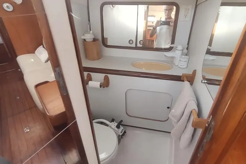 Slide: The Image of Interior of 1990 Beneteau Oceanis 390 yacht bathroom with sink, mirror, and toilet. - 15