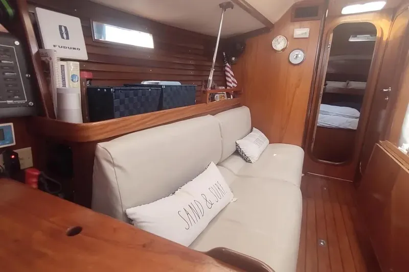 Slide: The Image of Interior of 1990 Beneteau Oceanis 390 sailboat with cozy seating and wooden finishes. - 16