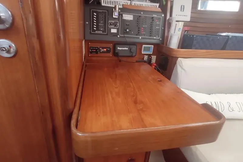 Slide: The Image of Navigation station on 1990 Beneteau Oceanis 390 yacht with control panels and wooden desk. - 17