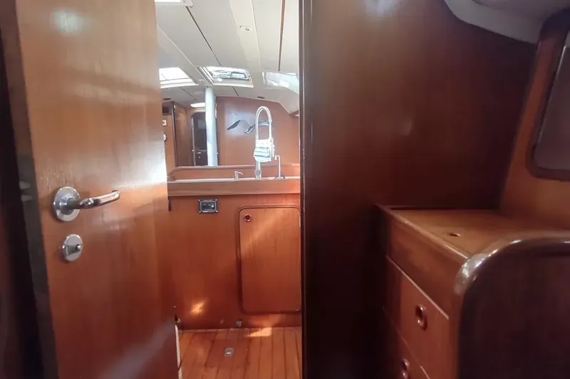 Slide: The Image of Interior of 1990 Beneteau Oceanis 390 sailboat with wooden cabinetry and modern fixtures. - 18