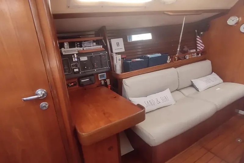 Slide: The Image of Interior of 1990 Beneteau Oceanis 390 sailboat with wooden finish and cozy seating area. - 19