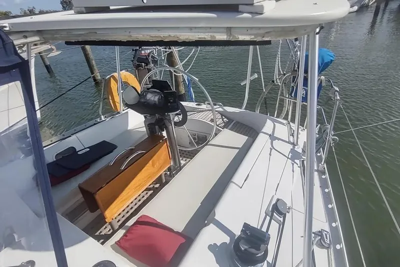 Slide: The Image of 1990 Beneteau Oceanis 390 sailboat cockpit with steering wheel and seating, docked at marina. - 2