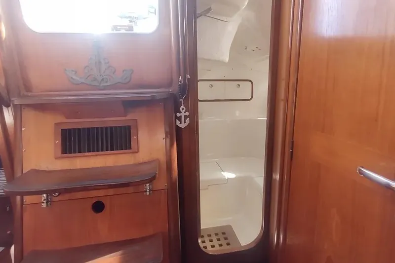 Slide: The Image of Interior of 1990 Beneteau Oceanis 390 sailboat, featuring wooden stairs and cabin entrance. - 20