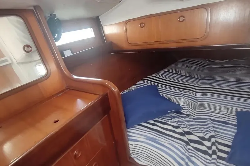 Slide: The Image of Cozy cabin interior of 1990 Beneteau Oceanis 390 sailboat with striped bedding. - 22