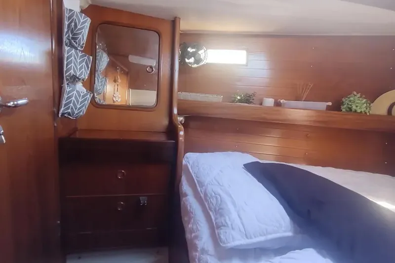 Slide: The Image of Cozy cabin interior of 1990 Beneteau Oceanis 390 sailboat with wooden furnishings and bed. - 23