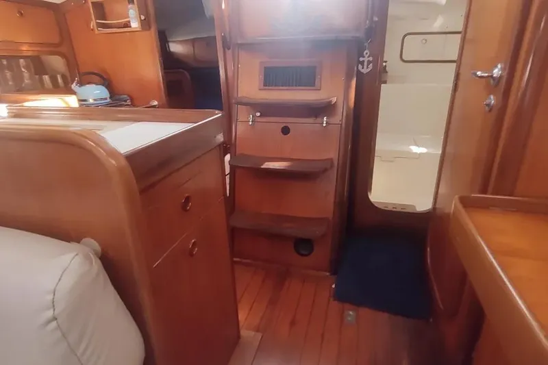 Slide: The Image of Interior of 1990 Beneteau Oceanis 390 sailboat with wooden cabinetry and cozy seating. - 25