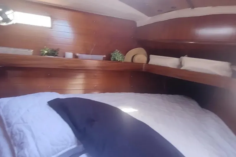 Slide: The Image of Cozy cabin interior of 1990 Beneteau Oceanis 390 sailboat with wooden paneling and bedding. - 27