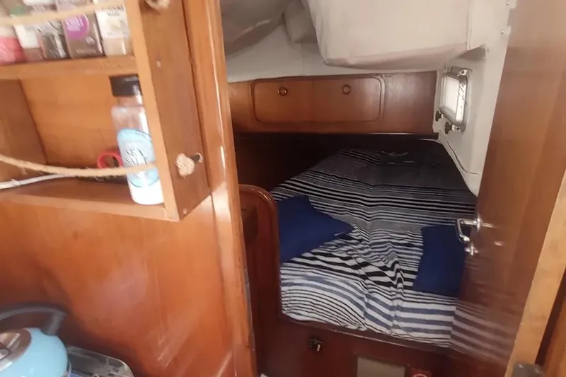 Slide: The Image of Cozy cabin interior of 1990 Beneteau Oceanis 390 sailboat with striped bedding. - 30