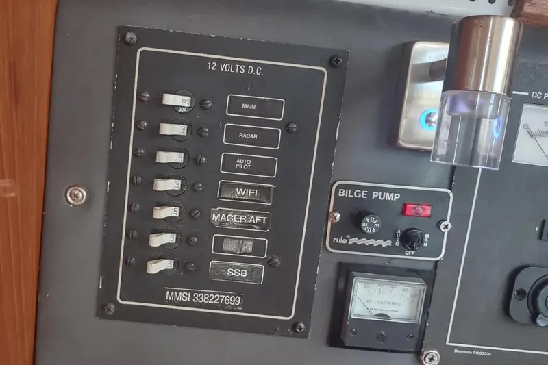 Slide: The Image of Control panel of a 1990 Beneteau Oceanis 390 sailboat, featuring switches and bilge pump controls. - 37