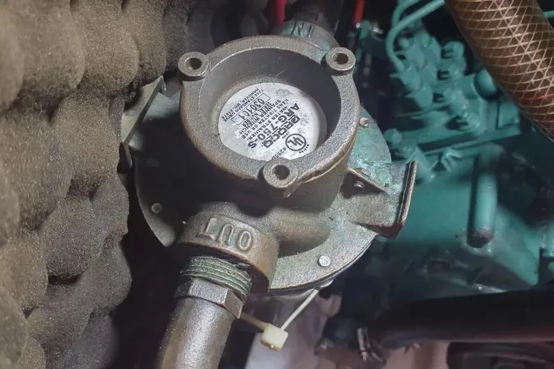 Slide: The Image of Engine component of a 1990 Beneteau Oceanis 390 sailboat, featuring a metal pump. - 39