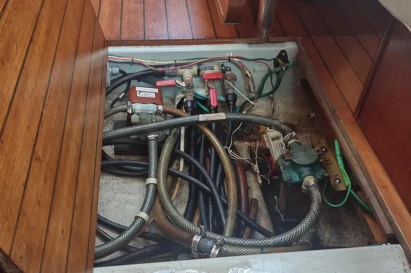 Slide: The Image of Engine compartment of a 1990 Beneteau Oceanis 390 sailboat, showing hoses and wiring. - 42