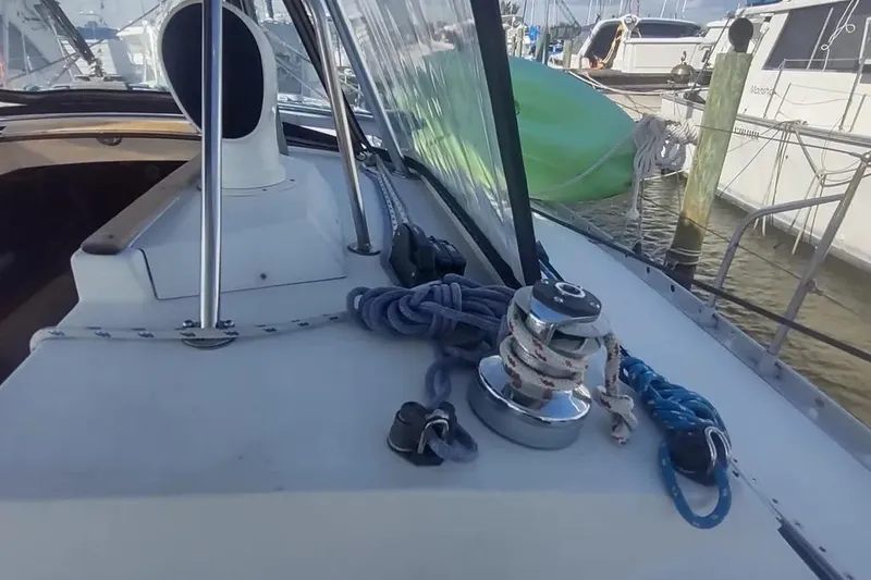 Slide: The Image of 1990 Beneteau Oceanis 390 sailboat deck with winch and ropes in marina. - 45