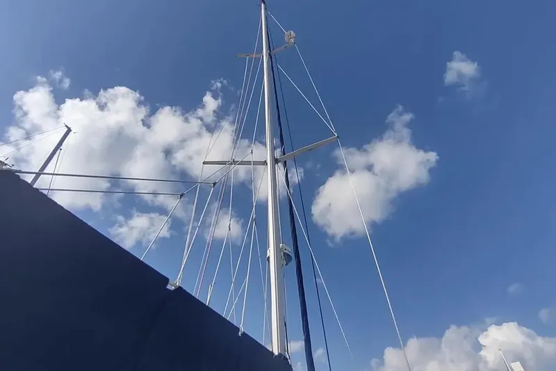 Slide: The Image of Mast of 1990 Beneteau Oceanis 390 sailboat against a blue sky with clouds. - 48