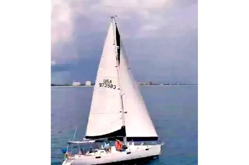 Slide: The Image of Sailing yacht Beneteau Oceanis 390, 1990 model, on calm waters under cloudy sky. - 57