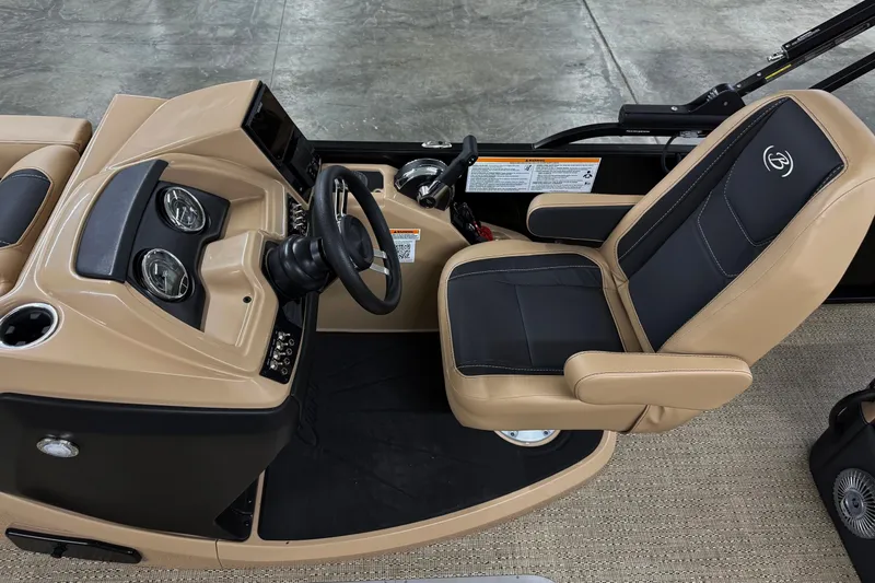 Slide: The Image of 2026 Barletta Cabrio 24UC boat interior with tan and black captain's chair and dashboard. - 12