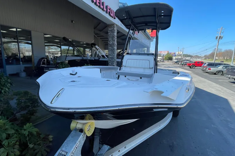 Slide: The Image of 2021 Yamaha Boats 195 FSH Sport displayed outside dealership, showcasing sleek design. - 13