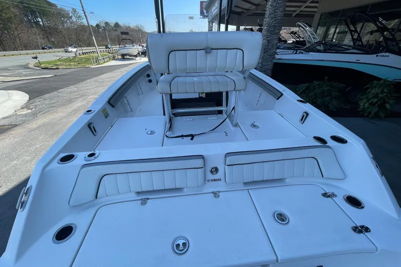 Slide: The Image of 2021 Yamaha Boats 195 FSH Sport interior, featuring white seating and storage compartments. - 14