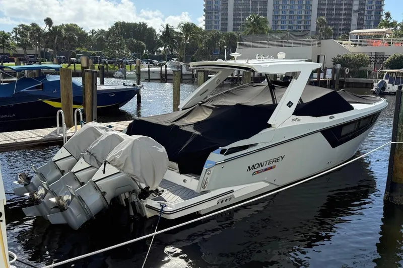 Slide: The Image of 2022 Monterey 385 Super Express boat docked with covered engines in a marina setting. - 5