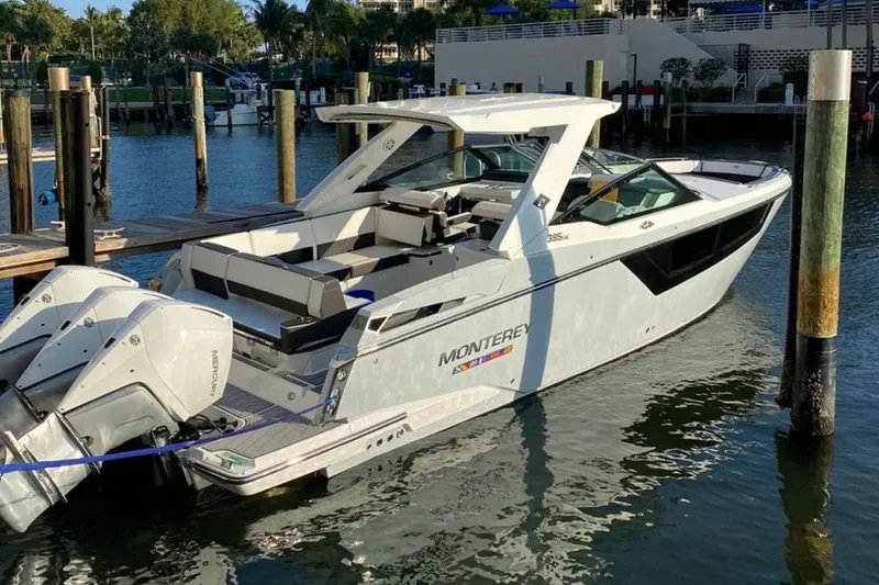 Slide: The Image of 2022 Monterey 385 Super Express boat docked in a marina, featuring twin outboard engines. - 7