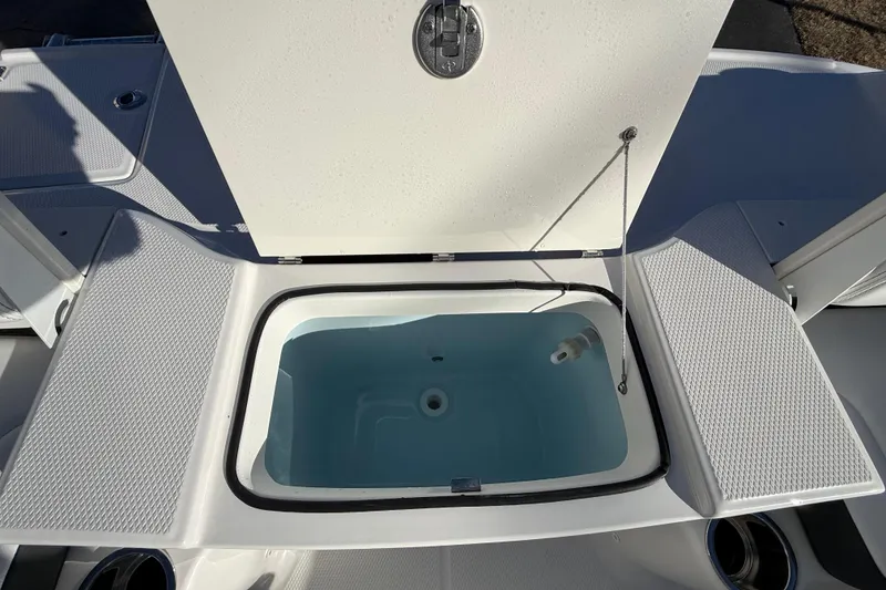 Slide: The Image of 2026 Robalo R200 Center Console livewell with open lid, showcasing interior design. - 11