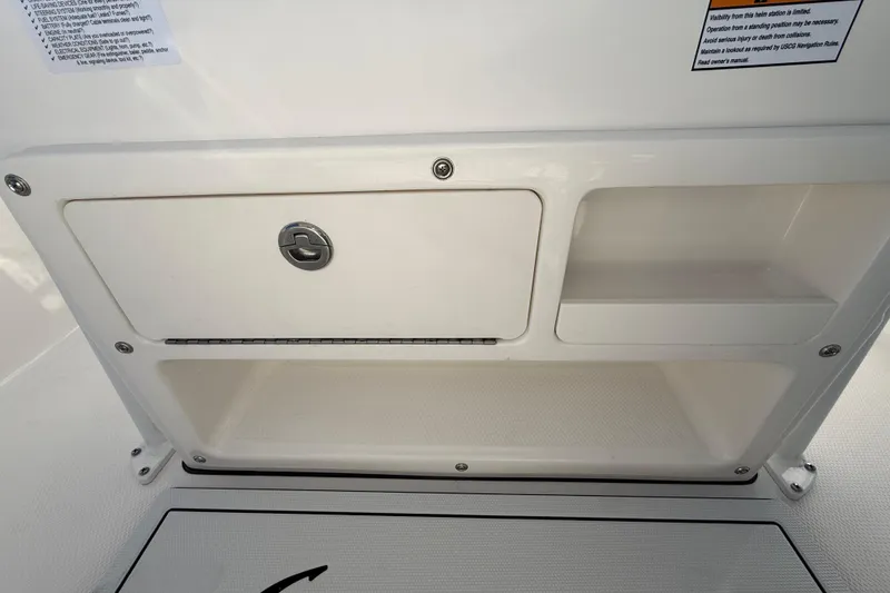 Slide: The Image of 2026 Robalo R200 Center Console storage compartment with lock and shelves. - 18
