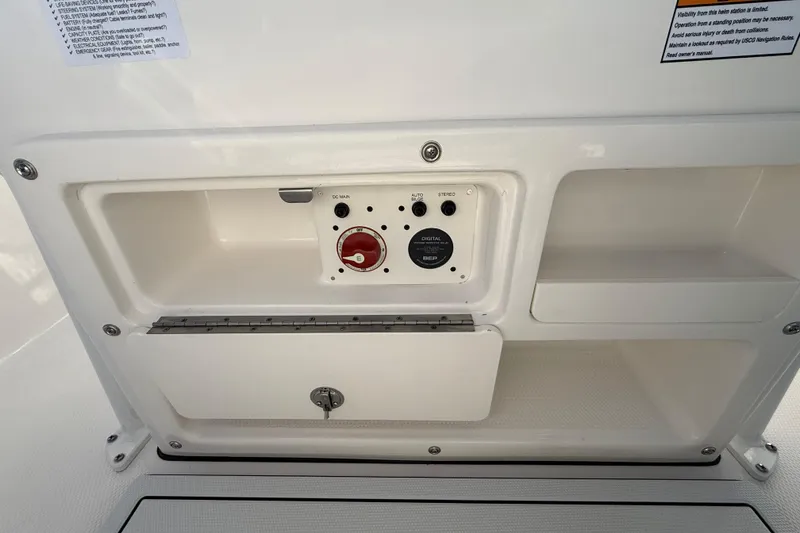 Slide: The Image of 2026 Robalo R200 Center Console boat control panel with storage compartments. - 19