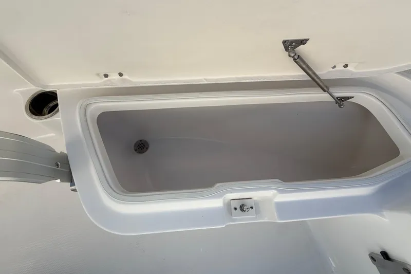 Slide: The Image of 2026 Robalo R200 Center Console storage compartment with open lid and hydraulic support. - 32