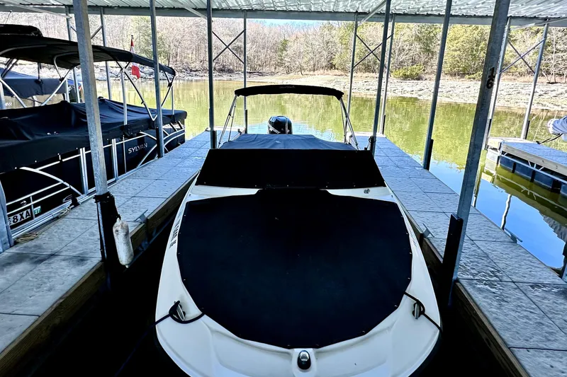 Slide: The Image of 2015 Sea Ray 21 SPX OB boat docked under a covered marina. - 12