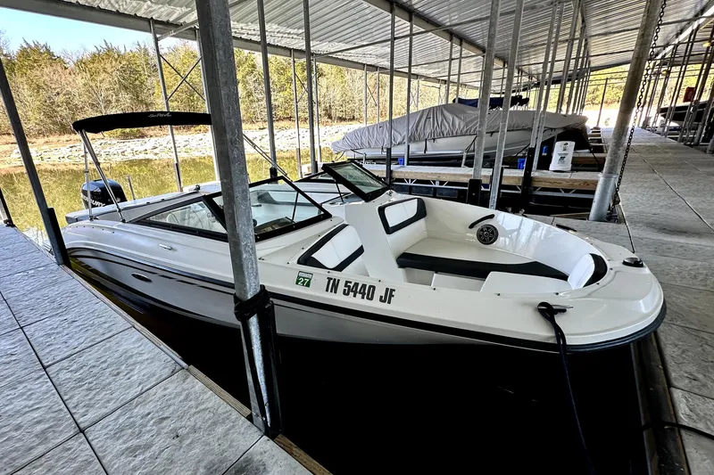 Slide: The Image of 2015 Sea Ray 21 SPX OB boat docked under a covered marina. - 2