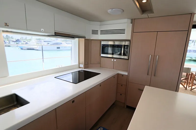 Slide: The Image of Modern yacht kitchen interior with sleek cabinetry, induction cooktop, and ocean view. Two Oceans 55, 2025 model. - 10