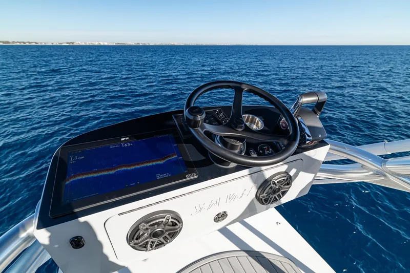 Slide: The Image of Control panel of 2026 SeaVee 420Z boat with digital display, on calm blue water. - 16