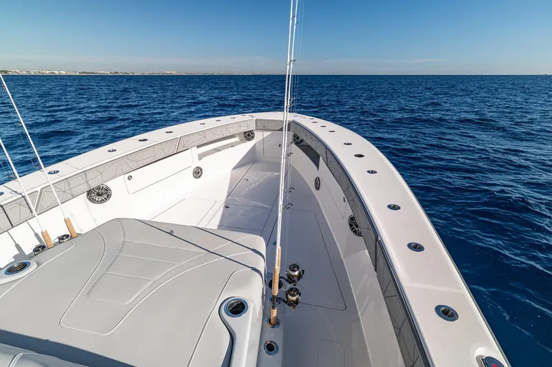 Slide: The Image of 2026 SeaVee 420Z boat on open ocean, showcasing spacious deck and fishing rods. - 64