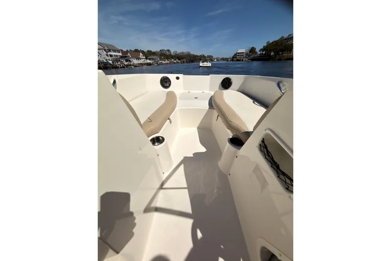 Slide: The Image of 2018 Stingray 191 DC boat interior with beige seating, cup holders, and waterfront view. - 10