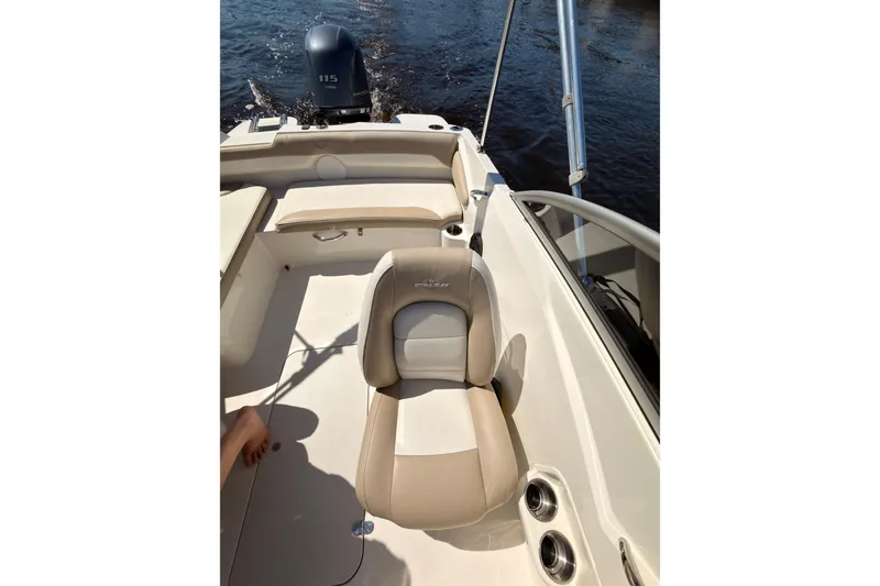 Slide: The Image of 2018 Stingray 191 DC boat interior with seating and outboard motor on water. - 12
