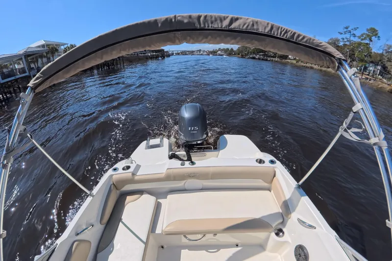 Slide: The Image of 2018 Stingray 191 DC boat cruising on a sunny river with a canopy. - 14