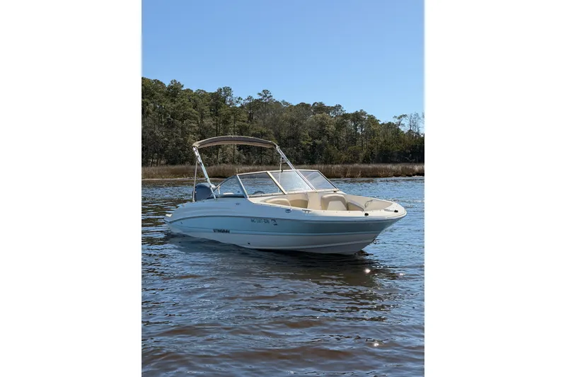 Slide: The Image of 2018 Stingray 191 DC boat on calm water with forested background. - 3