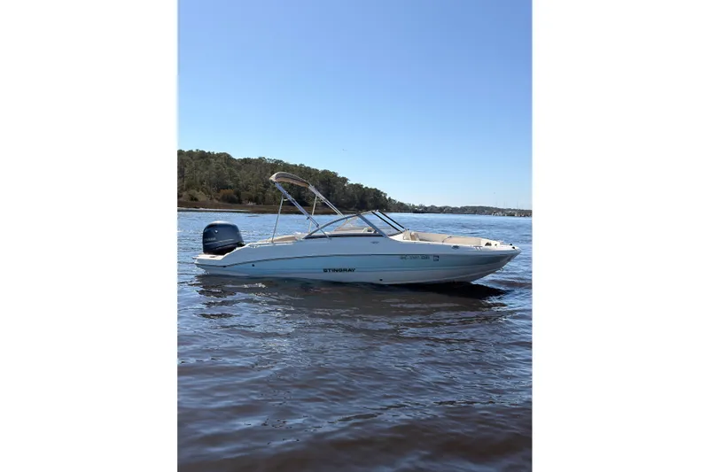 Slide: The Image of 2018 Stingray 191 DC boat on calm water with clear blue sky. - 4