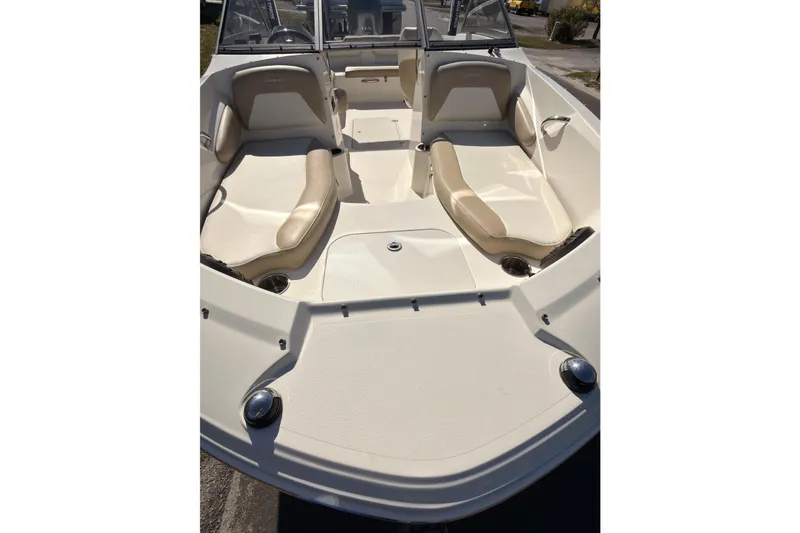 Slide: The Image of 2018 Stingray 191 DC boat interior with beige seating and open deck layout. - 5