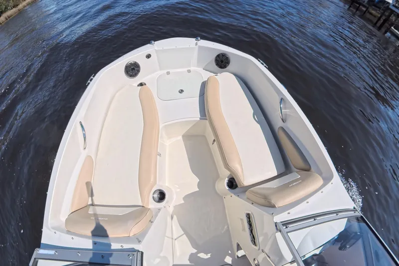 Slide: The Image of 2018 Stingray 191 DC boat interior with beige seating on calm water. - 8