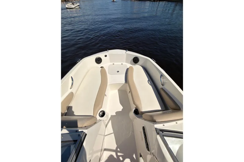 Slide: The Image of 2018 Stingray 191 DC boat interior with beige seating on calm water. - 9