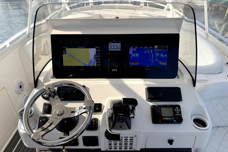 Slide: The Image of 2014 Intrepid 400 Cuddy boat interior with helm, seating, and rod holders. - 11