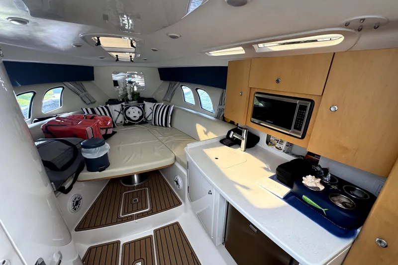 Slide: The Image of 2014 Intrepid 400 Cuddy boat interior with white seating and wooden table. - 16