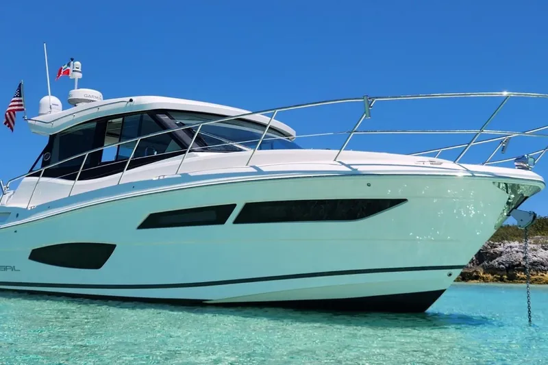 The Image of 2020 Regal 38 XO yacht in clear turquoise water, showcasing sleek design and luxury. - 0