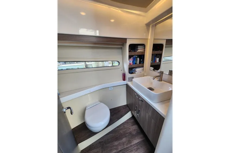 Slide: The Image of Modern bathroom in 2020 Regal 38 XO yacht with sink, toilet, and storage shelves. - 12