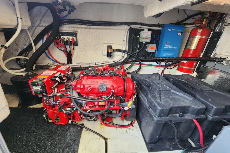 Slide: The Image of Engine room of 2020 Regal 38 XO with red Westerbeke generator and battery charger. - 15