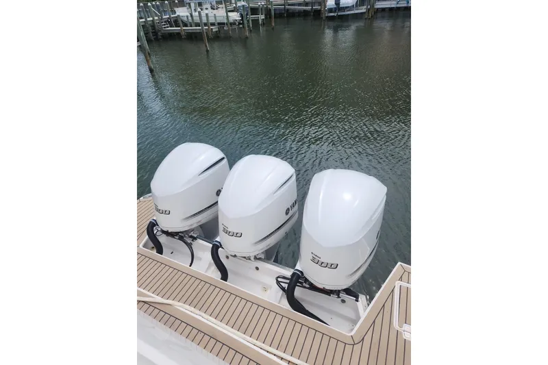 Slide: The Image of Triple Yamaha 300 outboard engines on 2020 Regal 38 XO boat, docked by water. - 3