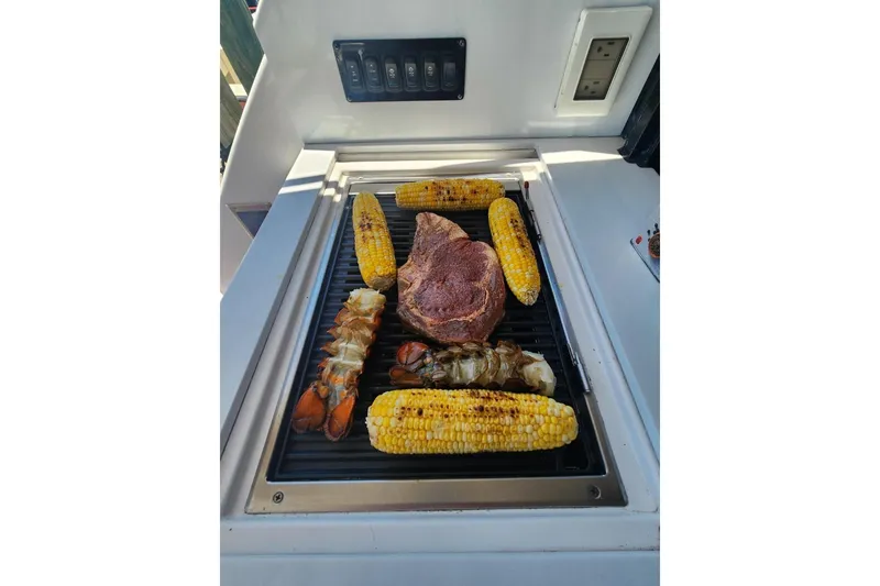 Slide: The Image of Grilled steak, lobster tails, and corn on Regal 38 XO yacht's outdoor grill. - 4